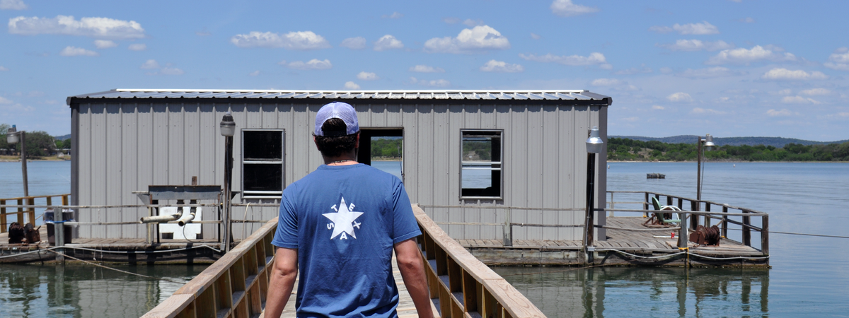 Texas Zavala Flag on a man walking on a dock on a lake